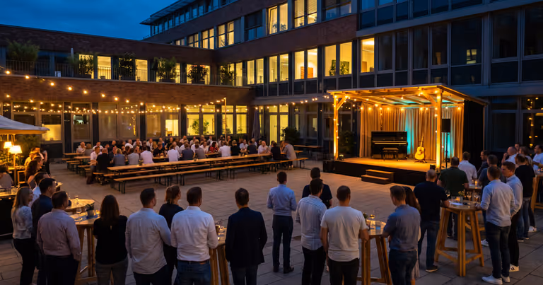Sommerliches Firmenfest im Innenhof mit Lichterketten und Bühne