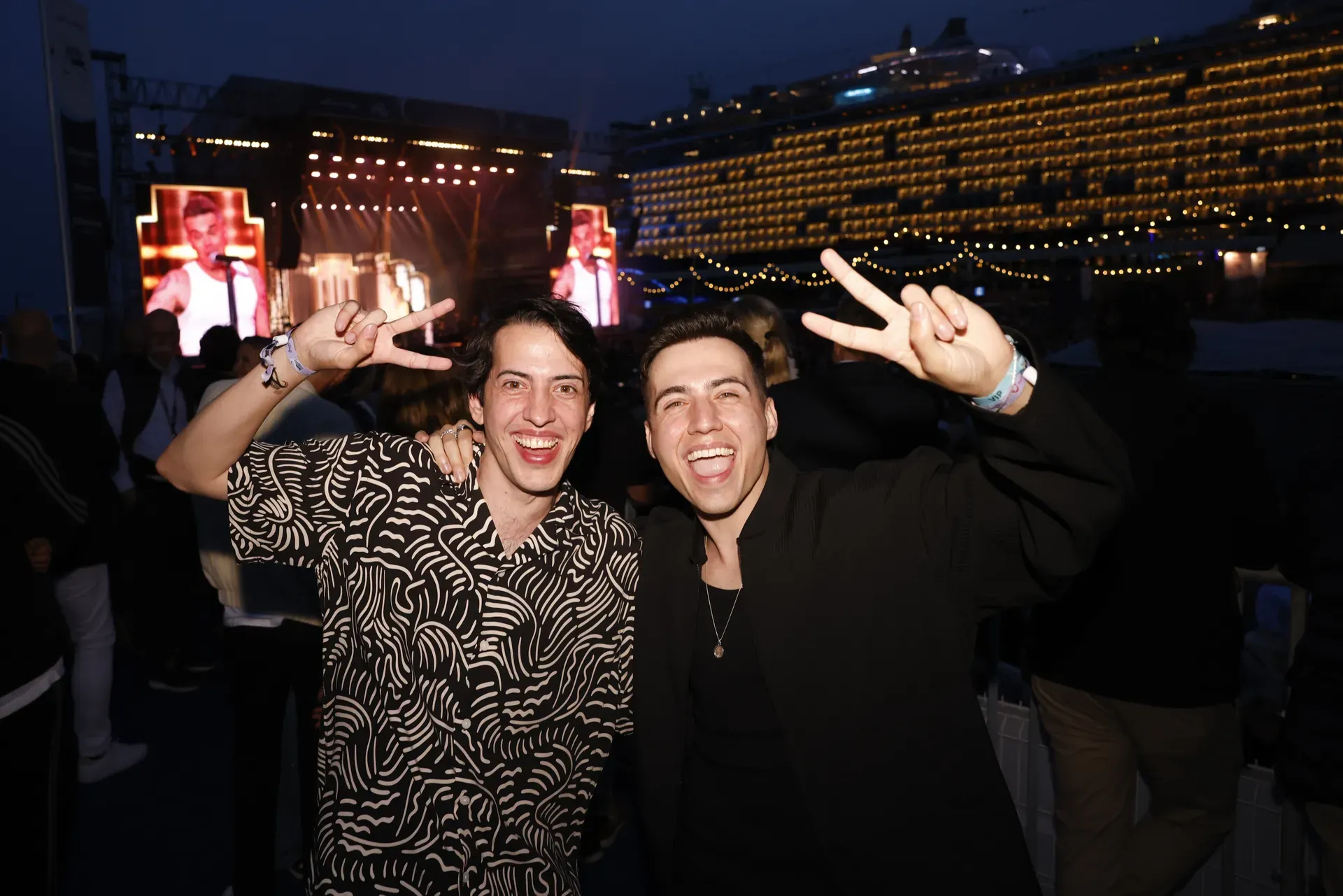 Mitchy & André am Abend der Taufzeremonie vor der beleuchteten Mein Schiff Relax in Málaga